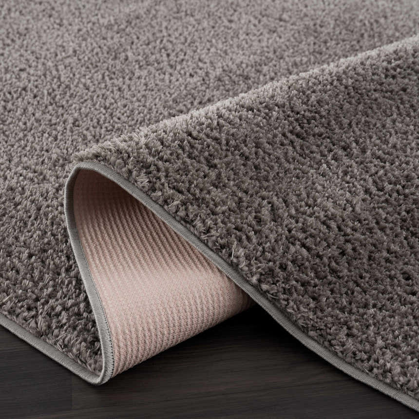 Close-up of the Judy Solid Dark Gray Washable Shag Rug showing its soft texture and durable backing. Fold