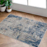 Sapcote Textured Luxe Area Rug in a bright room with wood floors and potted plants. Blue, beige, and gray abstract pattern. Roomscene-Rectangle