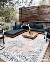 Outdoor patio with a Fullarton Performance Rug, wood furniture, and neutral decor. Roomscene-Rectangle