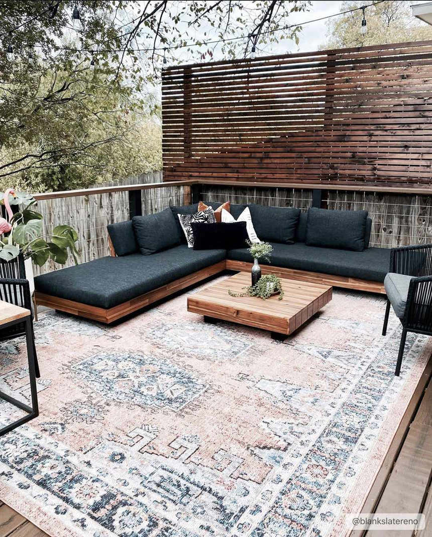 Outdoor patio with a Fullarton Performance Rug, wood furniture, and neutral decor. Roomscene-Rectangle