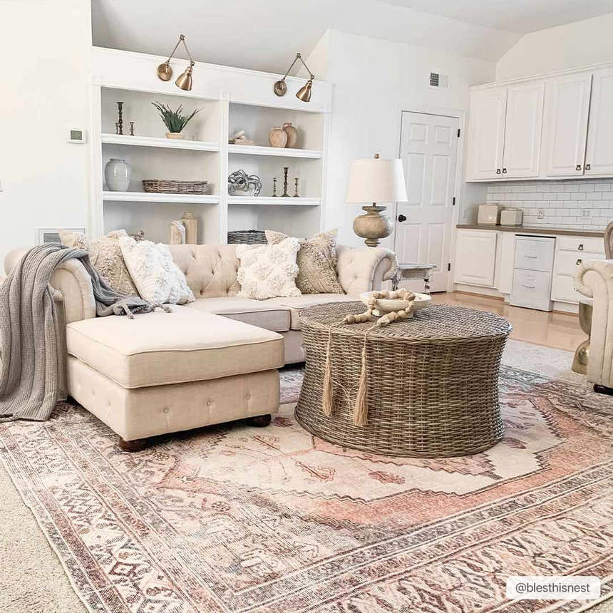 Living room scene with a beige sofa and Arncliffe Washable Area Rug in light peach tones, adding a bohemian touch. Roomscene-Rectangle