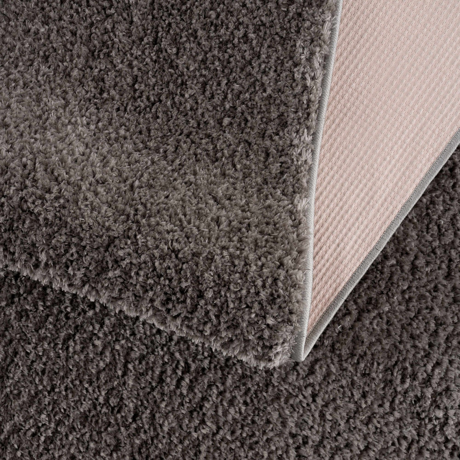 Close-up of the Judy Solid Dark Gray Washable Shag Rug showing its plush texture and durable backing. Fold