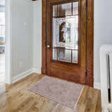 Entryway with a brown Deena Thick Luxe Area Rug, wood floors, and a decorative glass door. Roomscene-Rectangle