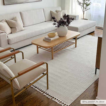Living room scene with a beige Abia Area Rug, white sofa, wood coffee table, and modern chairs. Roomscene-Rectangle