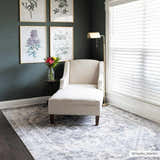 Living room scene with a gray Ailsa Area Rug, white chaise lounge, dark green walls, and botanical art prints. Roomscene-Rectangle