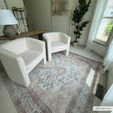 Living room scene with two white chairs on a light blue, brown, and tan Analu Non-Slip Washable Rug. Roomscene-Rectangle