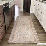 Kitchen scene with a tan Analu Non-Slip Washable Rug runner between wood and white cabinets on dark wood-look floors. Roomscene-Runner