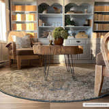 Cozy reading nook with a round Ange Cream & Blue Rich Textured Rug, wood stump table, and built-in bookshelves. Roomscene-Round