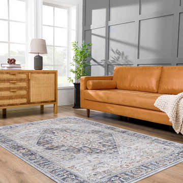Living room with light gray Jurou Area Rug, tan leather sofa, and wood cabinet. Farmhouse style. Roomscene-Rectangle