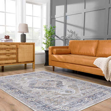 Living room scene with a light gray Lapis Area Rug, tan leather sofa, and wood cabinet. Roomscene-Rectangle