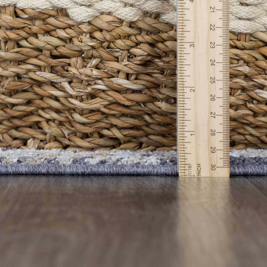 Close-up of Ivria Navy & Rust Area Rug showing light gray and natural gray tones with a ruler for scale. Woven texture detail. Pile