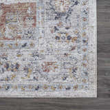 Close-up of the Ivria Blue Gray Area Rug showing its traditional pattern, texture, and colors on a dark wood floor. Swatch