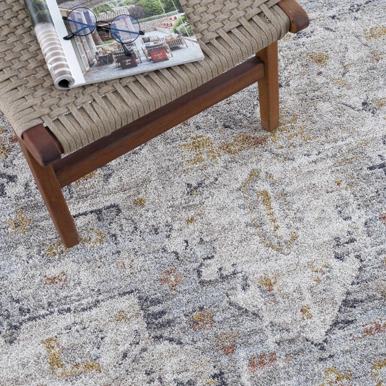 Close-up of the Ivria Blue Gray Area Rug, a farmhouse style rug with blue, gray, and gold tones. Styleshot