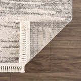 Close up of Lave Bone & Taupe Area Rug showing its bone and taupe striped design, fringe detail, and machine-woven construction. Fold