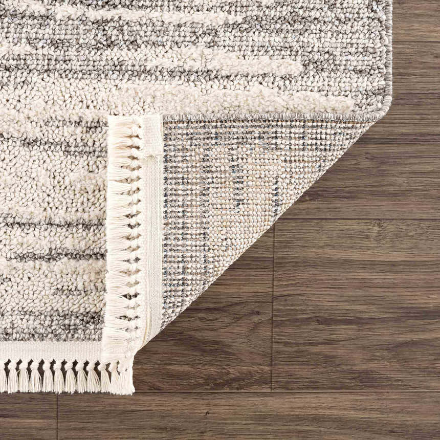 Close up of Lave Bone & Taupe Area Rug showing its bone and taupe striped design, fringe detail, and machine-woven construction. Fold