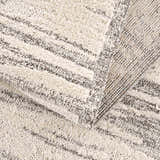 Close-up of Lave Bone & Taupe Area Rug showing its textured, high-pile design and neutral bone and taupe striped pattern. Fold