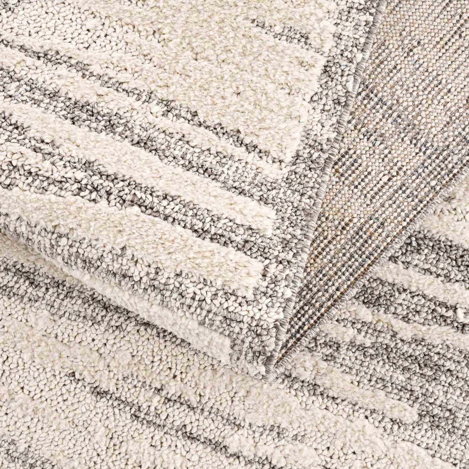 Close-up of Lave Bone & Taupe Area Rug showing its textured, high-pile design and neutral bone and taupe striped pattern. Fold