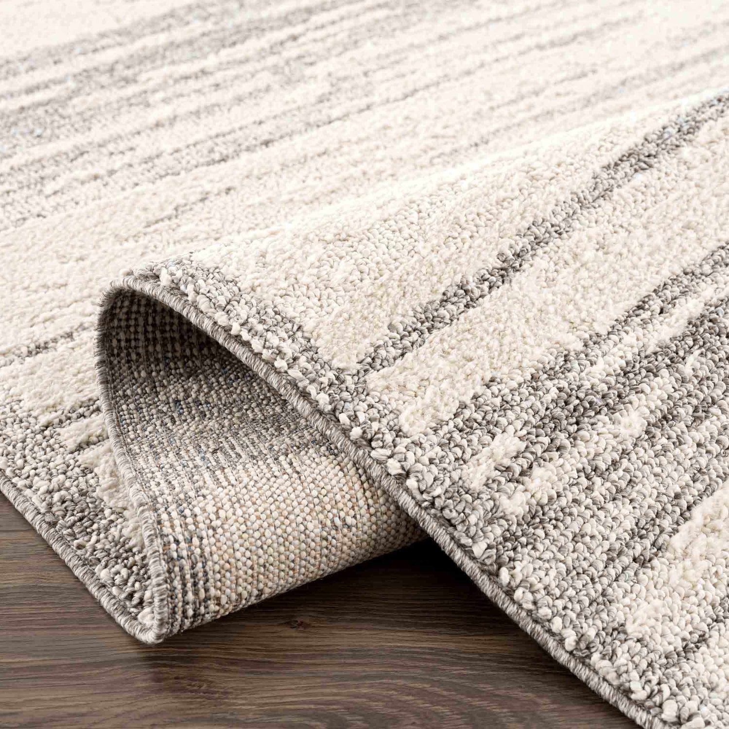 Close-up of the Lave Bone & Taupe Area Rug showing its textured weave and subtle bone and taupe striped pattern. Fold