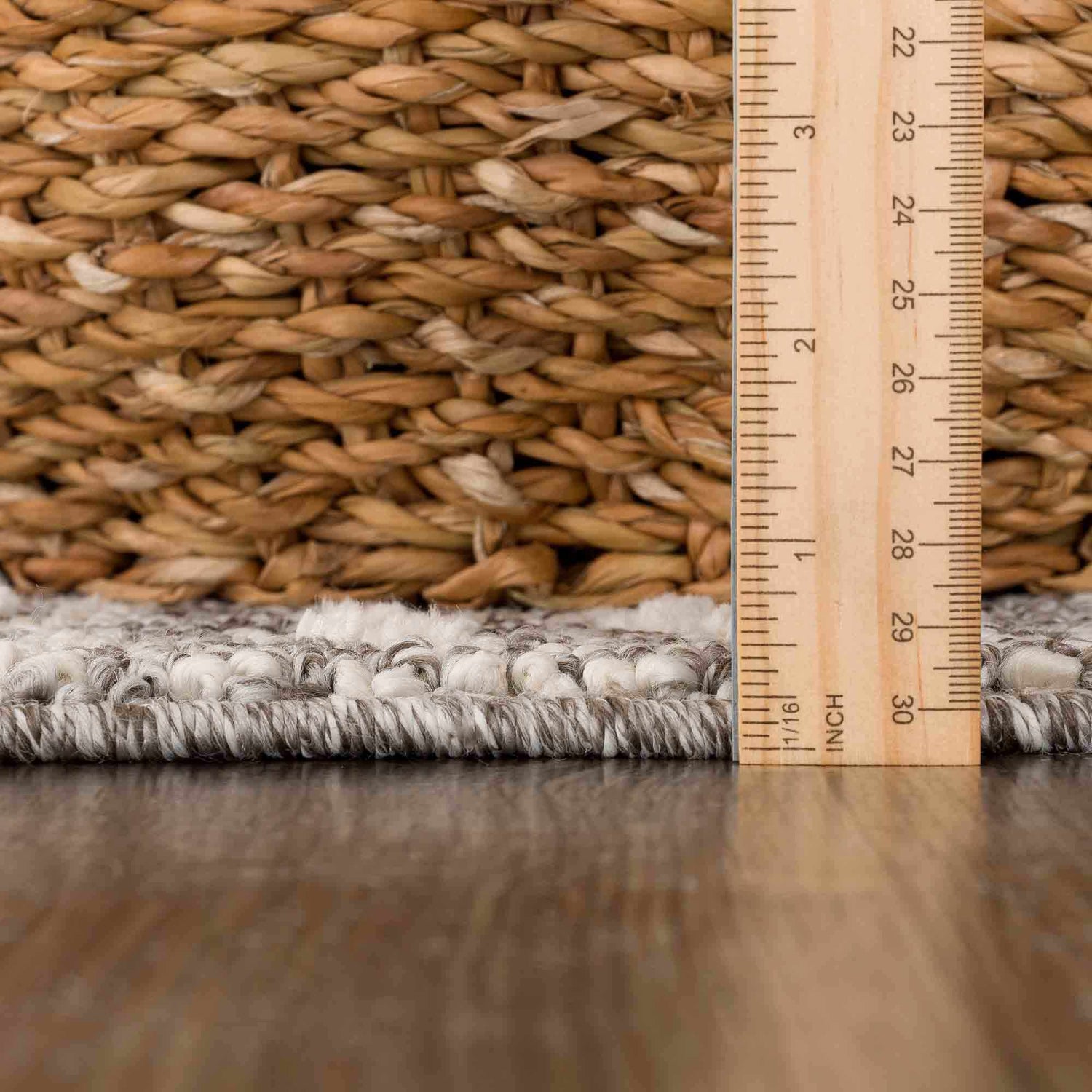 Close-up of the Lave Bone & Taupe Area Rug showing its bone and taupe tones, texture, and pile height with a ruler. Pile