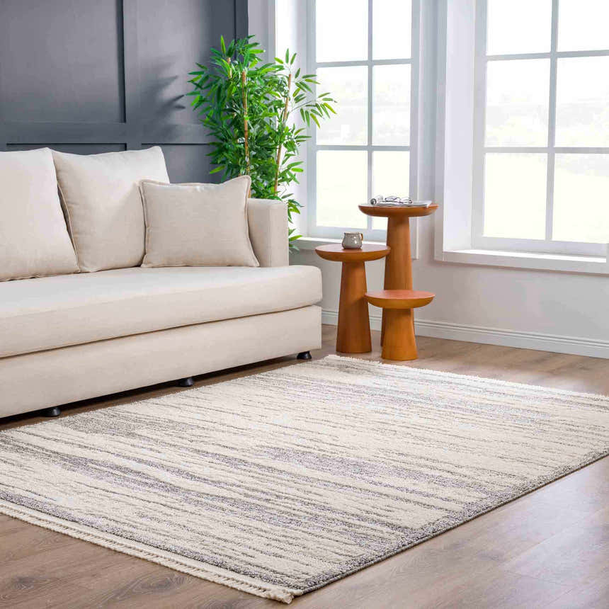 Living room scene with a bone sofa and Lave Bone & Taupe Area Rug. The rug features a subtle striped pattern in a neutral color palette. Roomscene-Rectangle