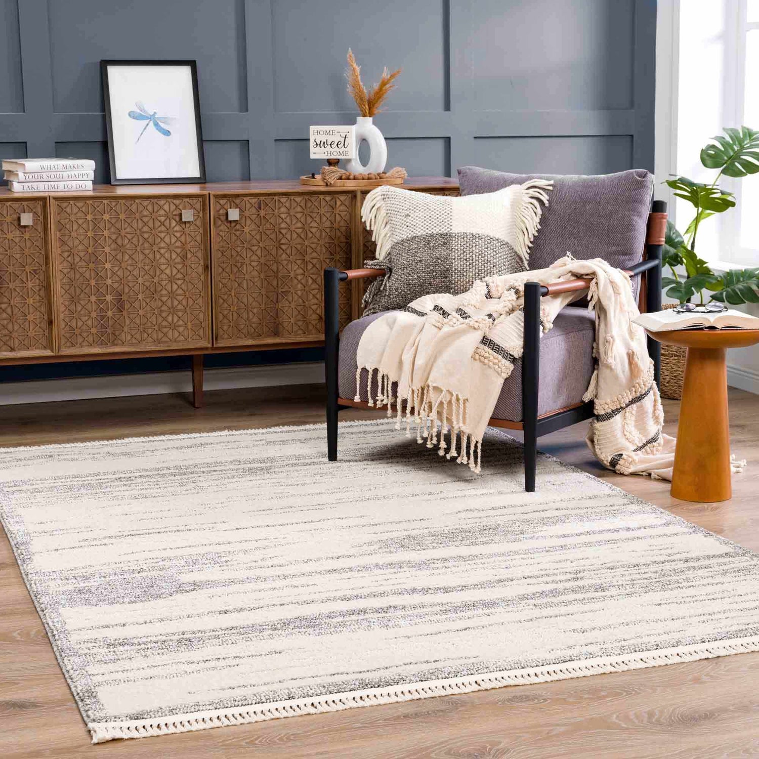 Living room scene with Lave Bone & Taupe Area Rug, gray chair, wood cabinet, and neutral decor. Contemporary style. Roomscene-Rectangle