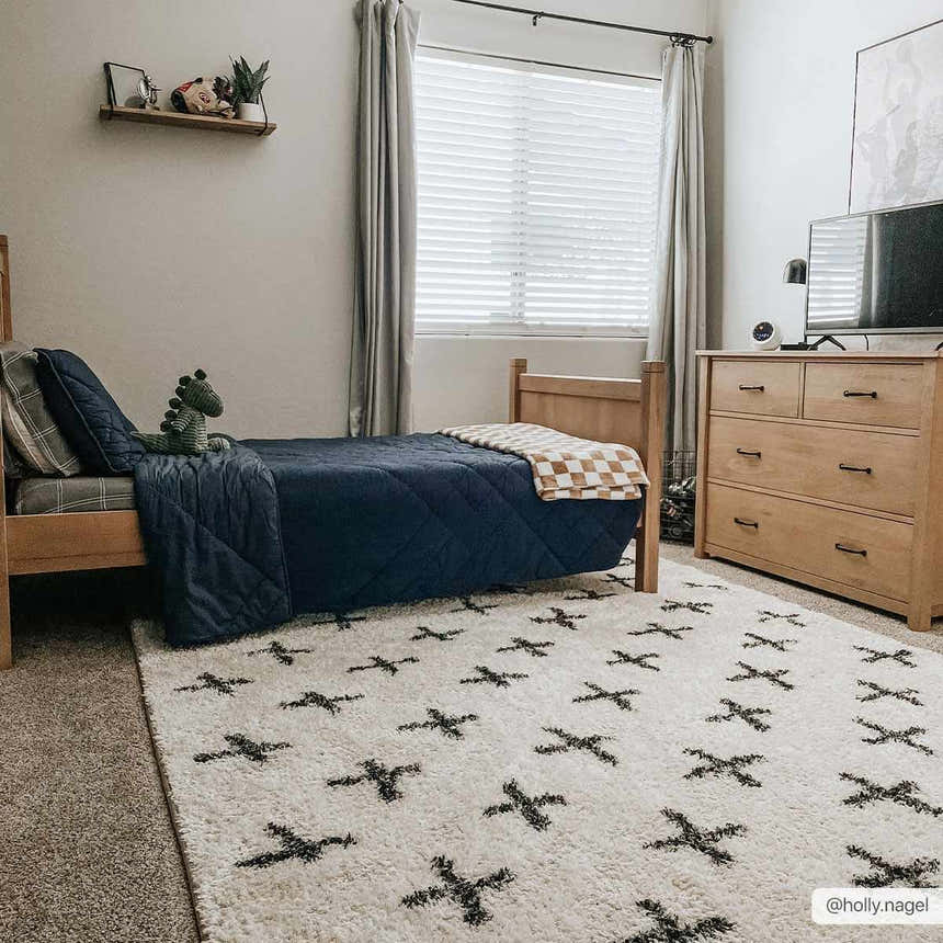 Kids bedroom with a light wood bed and the white Bede Washable Area Rug with black plus sign pattern. Roomscene-Rectangle