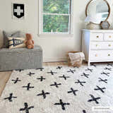 Kids room with a white dresser and the Bede Washable Area Rug in beige with a black plus sign pattern. Roomscene-Rectangle