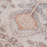 Close up of the Analu Non-Slip Washable Rug showing the traditional pattern in brown, tan, light blue, and dark red. Texture