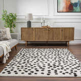 Living room scene with a Cansu Black & White Dotted Area Rug, gray sofa, and wood cabinet. Contemporary style. Roomscene-Rectangle