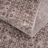 Close-up of the Lugo Luxe Area Rug showing its traditional, oriental pattern and soft charcoal and light gray colors. Fold