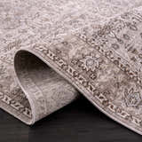 Close-up of a Lugo Luxe Area Rug. Oriental pattern in charcoal, ivory, and light gray. Machine woven polyester rug. Fold
