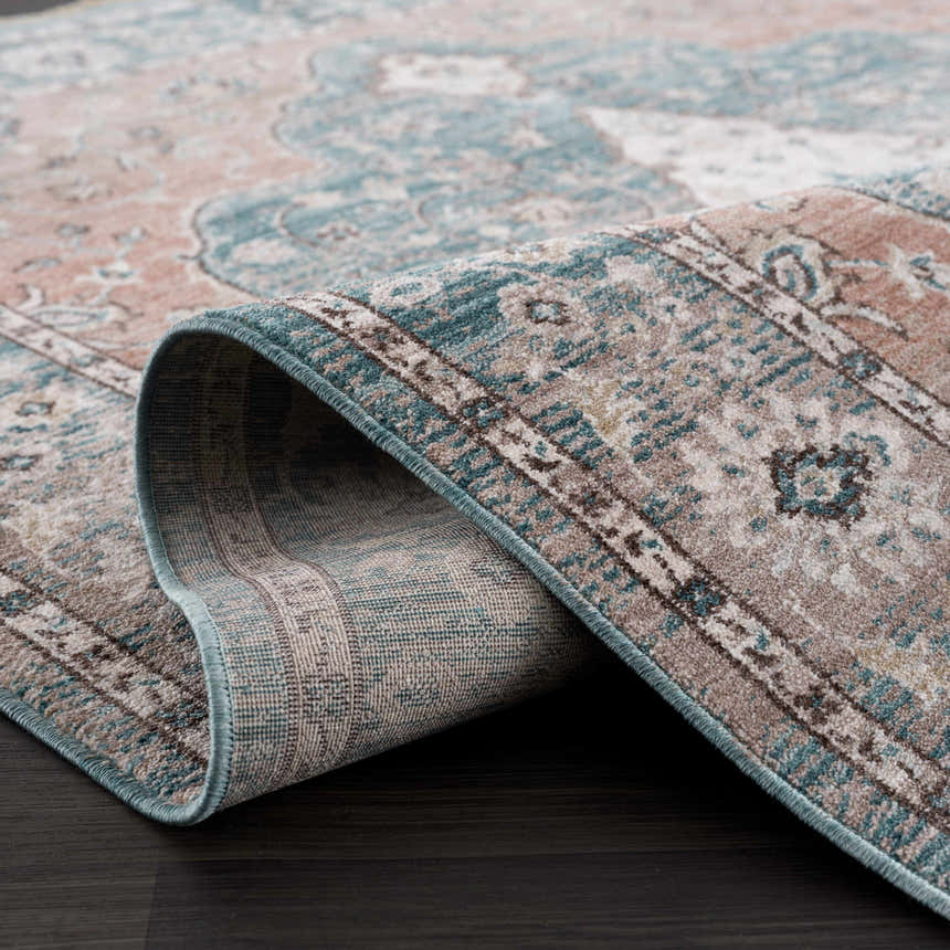 Close-up of the Edremit Area Rug showing its traditional pattern, soft texture, and colors: cream, blue, pink, and brown. Fold