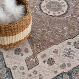 Close-up of the Baychester Area Rug showing its traditional oriental design, cream, brown, and teal colors, and soft texture. Styleshot