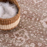 Close-up of the Kaongkod Area Rug showing its dusty pink, ivory, and brown traditional pattern and texture. Basket with white fur. Styleshot