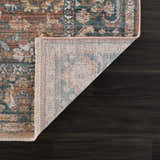 Close-up of the Mele Area Rug showing its traditional design, bone fringe, and colors: burnt orange, olive, and gray. Fold