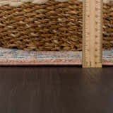 Close-up of the Mele Area Rug showing the pile height with a ruler, next to a woven basket. Colors: bone, burnt orange, and gray. Pile