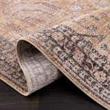 Close-up of the Darla Area Rug showing bone, clay, mocha, and dark gray traditional pattern and machine woven construction. Fold