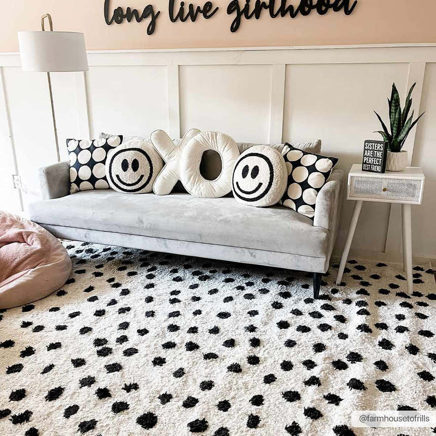 Girly bedroom scene with a Cansu Black & White Dotted Area Rug, gray sofa, and fun pillows. Roomscene-Rectangle