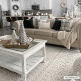 Living room scene with a Clenchwarton Textured Beige Rug, beige sofa, white coffee table, and Christmas decorations. Roomscene-Rectangle