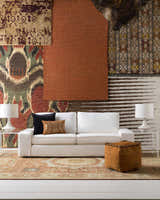 Living room scene with a Mercersburg Carpet in brick red, beige, and brown under a white sofa. Styleshot