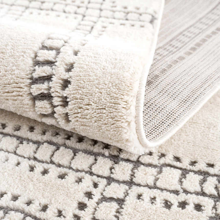 Close-up of the Ryuu Ivory & Gray Area Rug showing its plush texture and contemporary geometric pattern. Fold