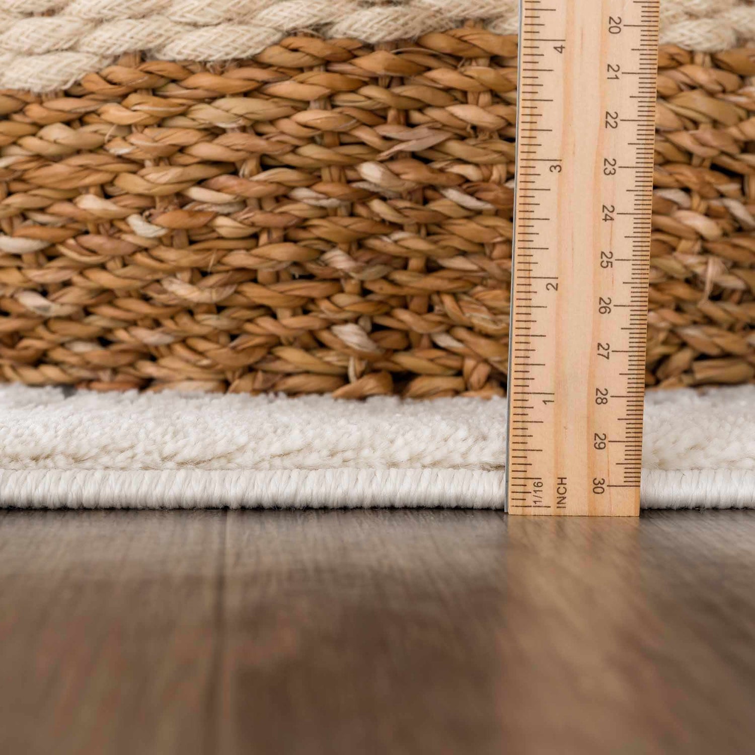 Close-up of the Ryuu Ivory & Gray Area Rug showing its plush pile and the thickness of the rug with a ruler. Pile