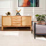 Living room scene with a Ryuu Ivory Carved Area Rug, wood cabinet, gray chair, and colorful abstract art. Roomscene-Rectangle