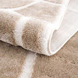 Close up of the plush Azana Cream Area Rug showing its geometric pattern and soft texture. Fold