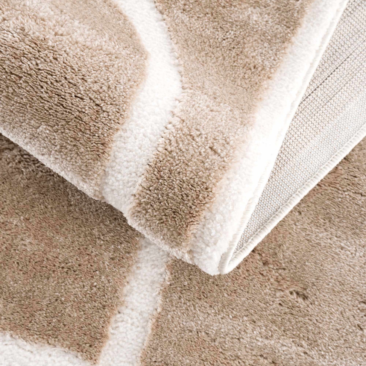 Close-up of the Azana Cream Area Rug showing the soft texture, geometric pattern, and durable backing. Fold