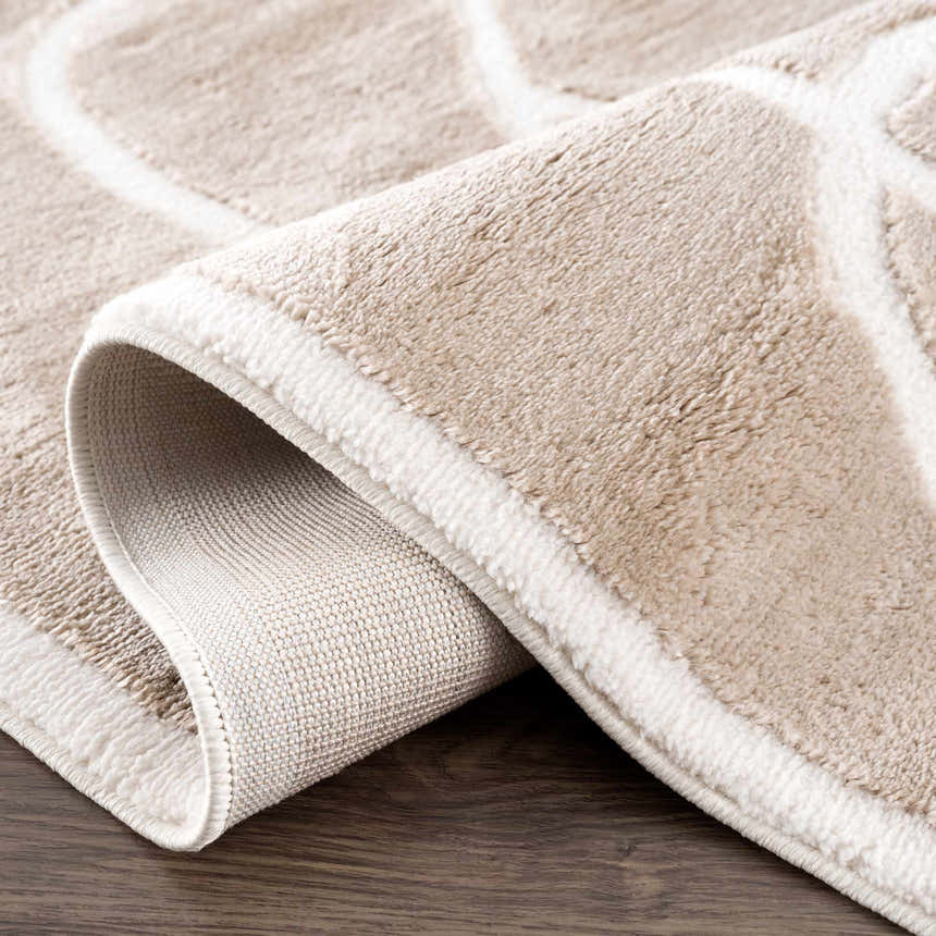 Close-up of the Azana Cream Area Rug showing its geometric pattern, plush texture, and durable backing. Fold