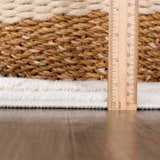 Close-up of the Azana Cream Area Rug showing the rug's pile height with a ruler on a wood floor. Pile