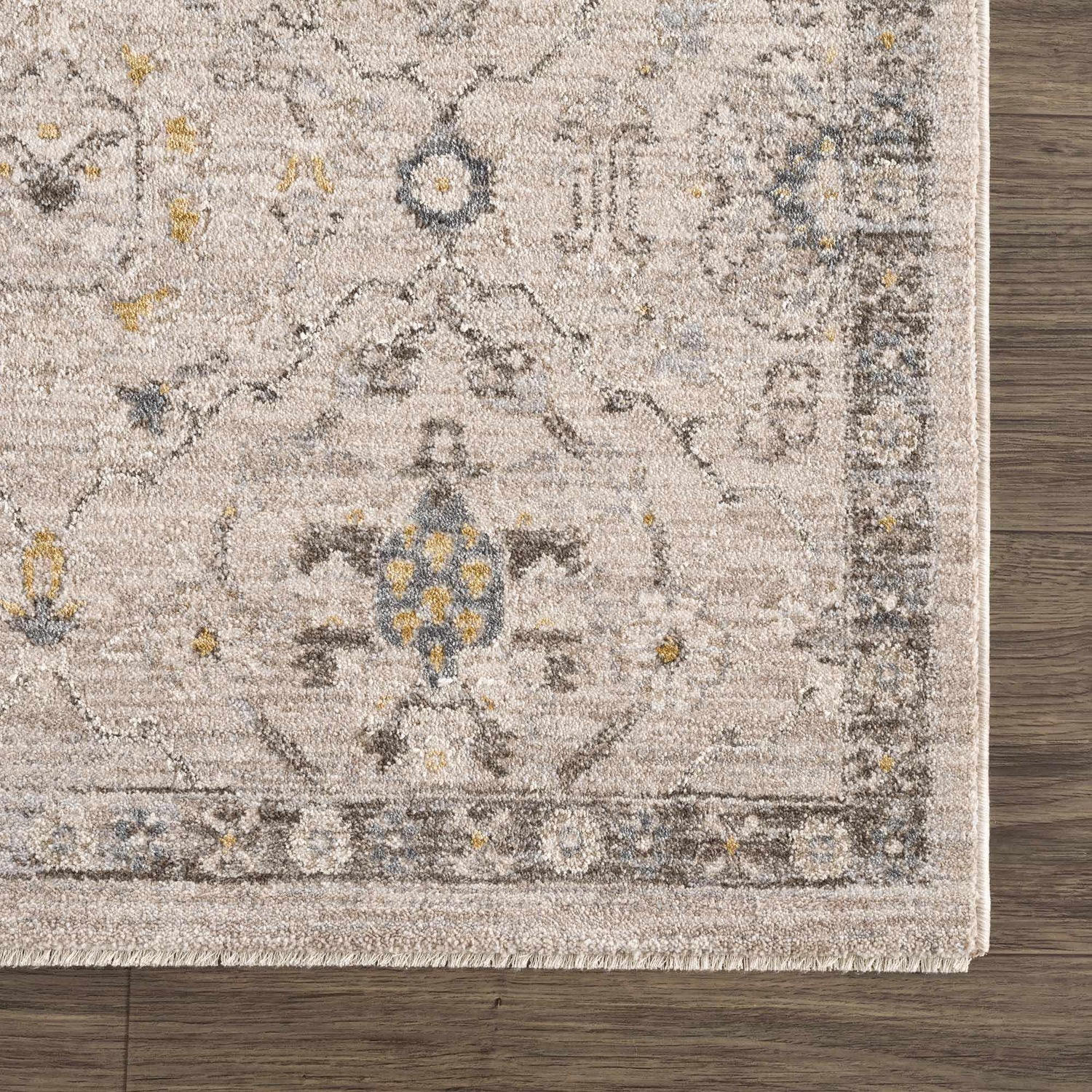 Close-up of the Annie Cream Textured Rug showing its farmhouse style pattern and soft, neutral colors on a wood floor. Swatch
