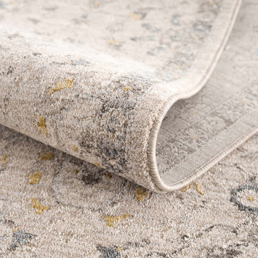 Close-up of the Annie Cream Textured Rug with Fringes showing the cotton and polyester blend, and machine woven construction. Fold