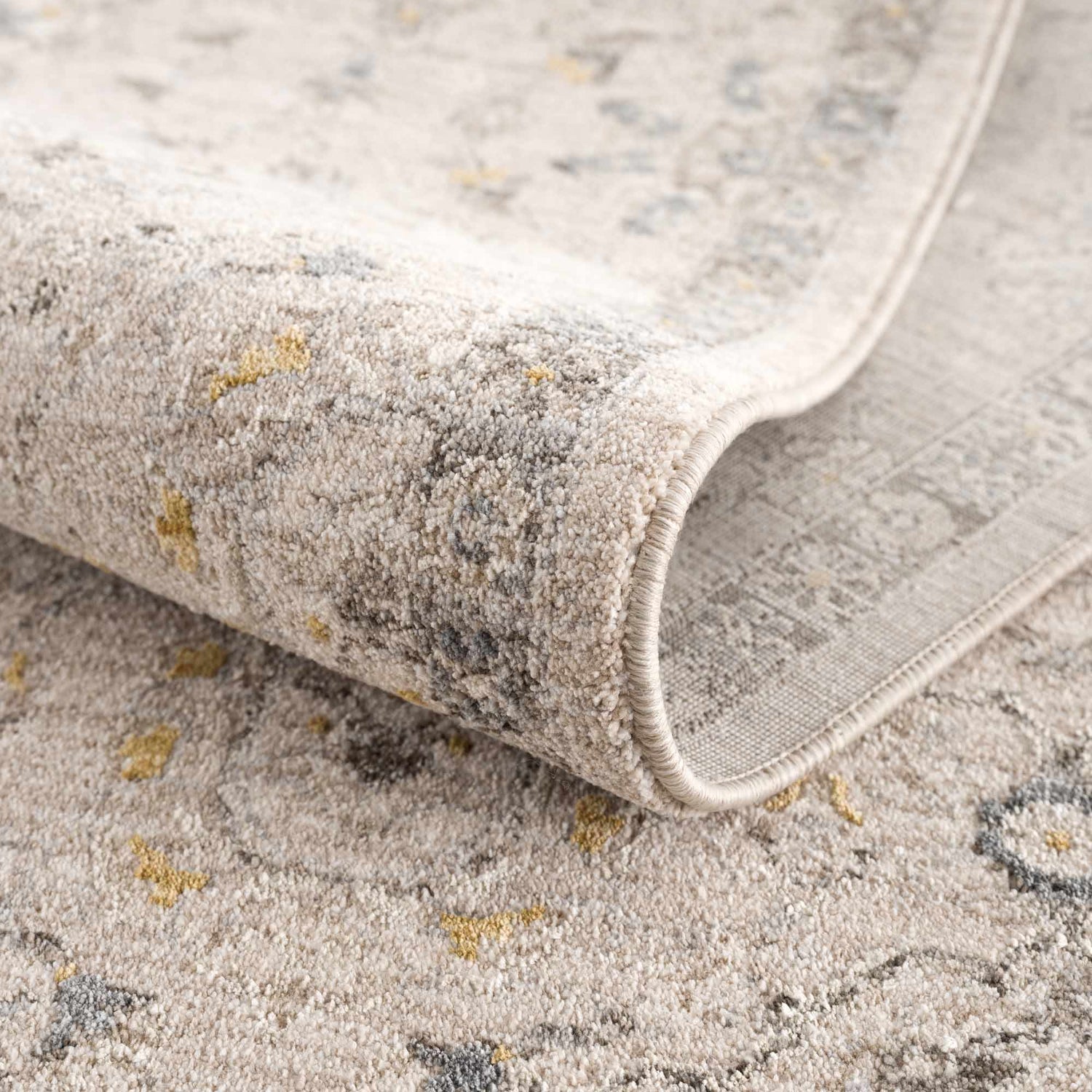 Close-up of the Annie Cream Textured Rug with Fringes showing the cotton and polyester blend, and machine woven construction. Fold